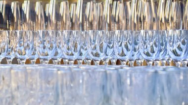 Kristal bardaklar, kadehler, şarap kadehleri bir sıra yükseklikte, biri diğerinin üstünde duruyor..
