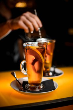 Uzun şeffaf bardaklara ve barın üstünde limonlu lezzetli sıcak çaya odaklan.