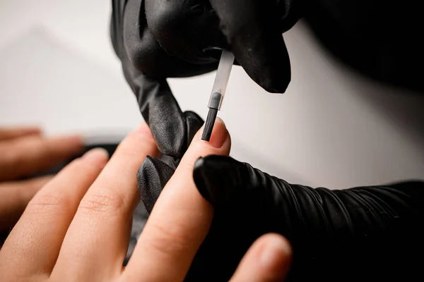 Close Mãos Manicure Luvas Pretas Cobrindo Prego Com Base Transparente — Fotografia de Stock