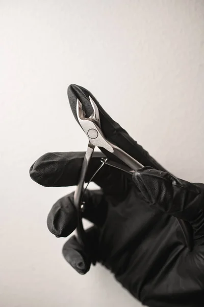 Close Van Professionele Stalen Nagelknippers Hand Met Zwarte Handschoen Begrepen — Stockfoto