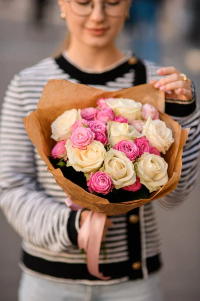 선택적으로 손으로 종이를 분홍빛 장미로 아름다운 꽃다발에 초점을 맞추라 클로즈업 — 스톡 사진