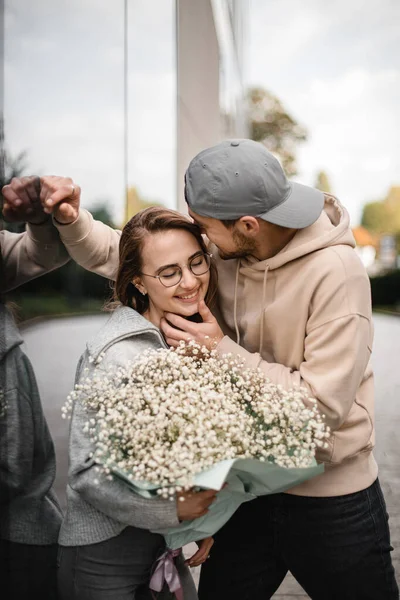 男がキスする花の花束を持つ魅力的な女性を笑顔の素晴らしい景色 愛のカップル ロマンチックなデート — ストック写真