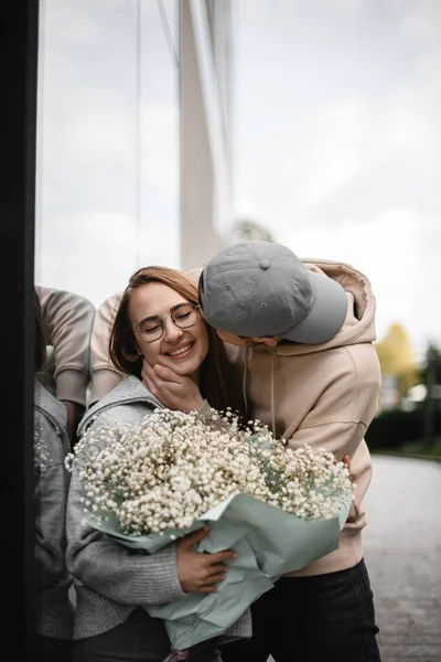 남자가 키스하고 사랑하는 꽃다발을 매력적 여자가 모습을 낭만적 데이트 — 스톡 사진
