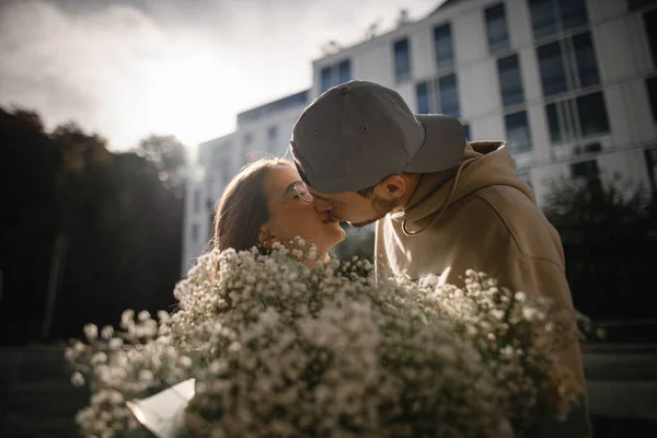 若い美しい女性と男にキスをする頭の上に素晴らしいクローズアップビュー 前景に咲く花の花束 — ストック写真