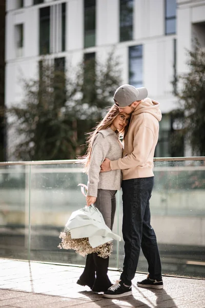 beautiful view of young hugging couple in love, girl and boyfriend, in the city. Romantic date