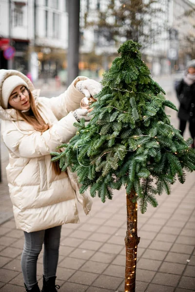 Νεαρή Γυναίκα Διακοσμεί Απαλά Γιρλάντα Ζωντανά Πράσινο Χριστουγεννιάτικο Έλατο Δέντρο — Φωτογραφία Αρχείου
