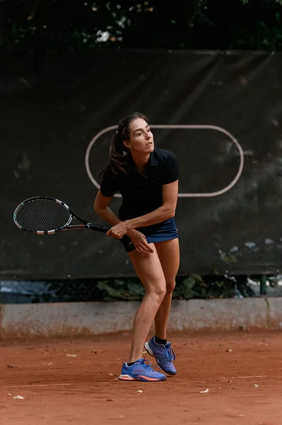 woman playing tennis and waiting tennis ball. Training at outdoor tennis court. Outdoor tennis practice.