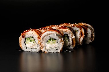delicious sushi rolls Philadelphia with smoked eel, avocado, cream cheese on dark background. Sushi menu. Japanese food.