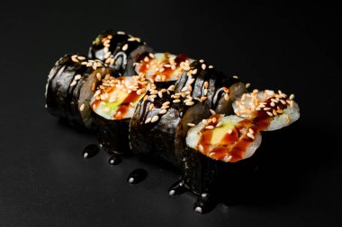 vegetarian sushi rolls with tofu and rice wrapped in nori drizzled with soy sauce and sesame seeds. Healthy vegan food concept. Japanese food.