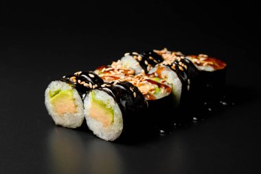 view of vegetarian sushi rolls with tofu and rice wrapped in nori drizzled with soy sauce and sesame seeds. Healthy vegan food concept. Japanese food.