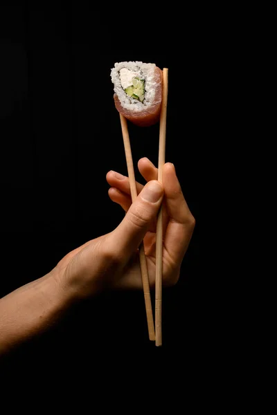 Female Hand Gently Holding Philadelphia Maki Roll Bamboo Chopsticks Dark — Stok fotoğraf