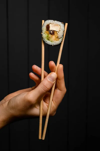 Female Hand Holds Sushi Roll Smoked Eel Avocado Cream Cheese — Stok fotoğraf
