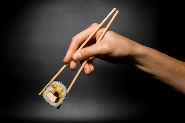 Female Hand Accurate Holds Sushi Roll Smoked Eel Avocado Cream — 图库照片