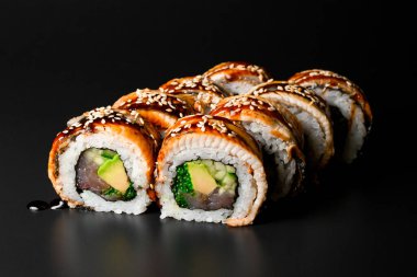 delicious Philadelphia sushi rolls with rice, salmon, eel, cucumber, avocado, tobiko caviar, nori, Philadelphia cheese, soya sauce and sesame