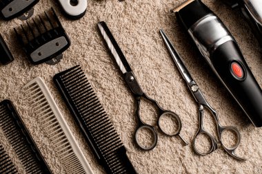 Close-up top view on table with professional scissors, combs, hair brushes and hair clips, trimmer. Barbershop.