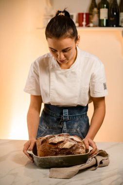 woman holding fresh rustic organic bread from the oven, baking homemade bread, sourdough bread delicious and natural products, healthy food baking