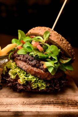 Tahtada taze marul ve ıspanakla büyük ve lezzetli bir çift hamburger.