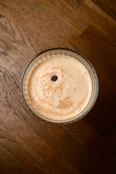 用咖啡豆装饰在木制桌子上的美味可口的泡沫咖啡杯的特写镜头 — 图库照片