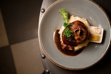 Tabakta otlarla süslenmiş lezzetli kızarmış domuz budu manzarası.