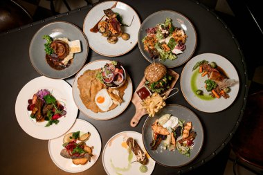 Tabakların, balıkların, salataların ve abur cuburların olduğu bir masa.