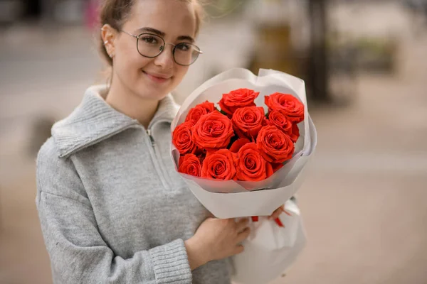 Счастливая Красивая Молодая Женщина Букетом Ярко Красных Роз Оберточной Бумаге — стоковое фото