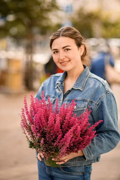 Wanita Tersenyum Memegang Pot Bunga Besar Dengan Tumbuh Tanaman Heather — Stok Foto