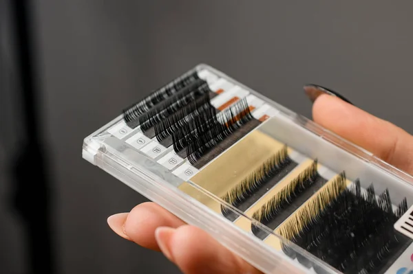 close-up on a plastic box with artificial eyelashes of different sizes in a female hand