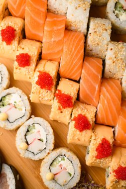 Japon usulü maki suşi, ton balığı, tobiko havyarı, somon, krem peynir, avokado ve susamlı. Yakın çekim görüntüsü.