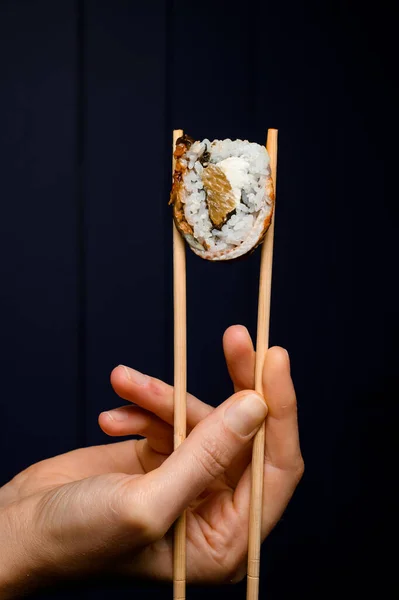 Kéz Tartja Philadelphia Sushi Tekercs Füstölt Angolna Lazac Krémsajt Bambusz — Stock Fotó