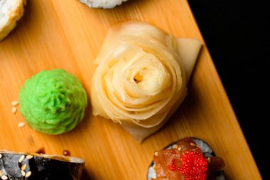 Japon yemeklerini tahta kesme tahtasıyla süslemek için beyaz zencefil ve yeşil wasabi karışımı. Üst görünüm.
