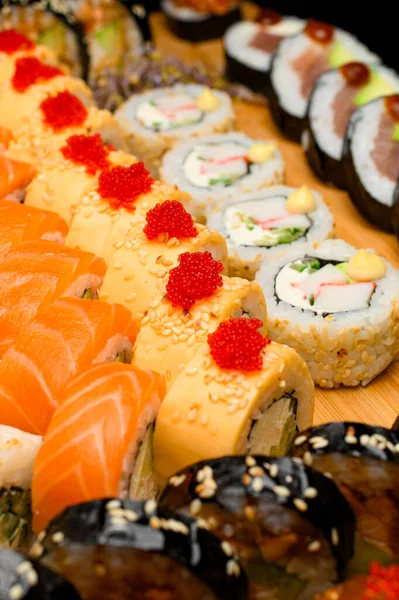 食品横幅 木制切板上的一组不同的滚筒 配上鲑鱼 烤肉卷 芝麻和寿司卷 图库图片