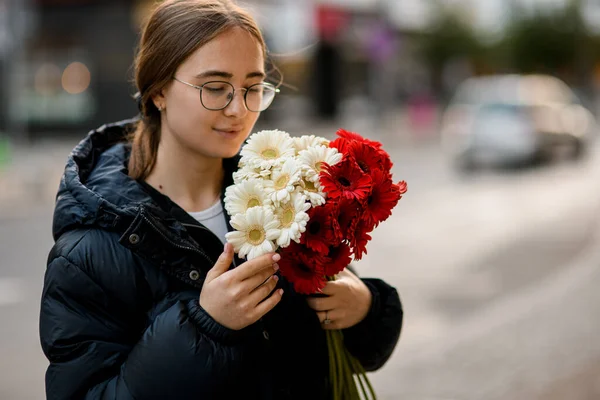 Όμορφη Νεαρή Γυναίκα Κρατώντας Μπουκέτο Από Κόκκινα Και Λευκά Λουλούδια — Φωτογραφία Αρχείου