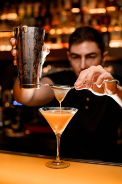 Çelik bardakların güzel manzarası ve barmen jigger 'dan bardağa su dolduruyor.