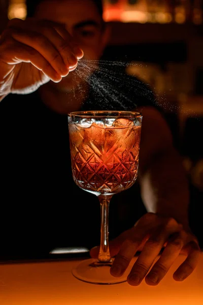 Jonge Barman Besprenkelt Glas Met Amberkleurige Alcoholische Cocktail Met Een — Stockfoto