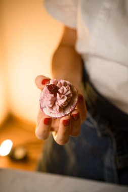 Kadınların elinde, reçel ve ganache ile süslenmiş Fransız tatlı makaronunun yarısı var. Manzarayı kapat. Ev pastası konsepti