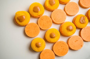 Ganache ve meyve reçeli ile süslenmiş taze turuncu kremalı tatlı. Şekerlemeler ve pişirme konsepti