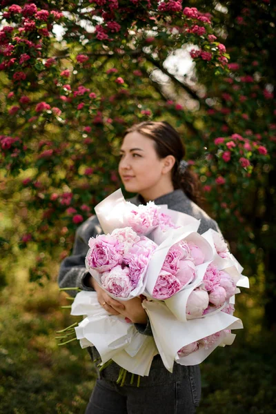 Młoda Dziewczyna Trzyma Duże Bukiety Różowych Świeżych Piwonii Sprzedaż Kwiaciarni — Zdjęcie stockowe
