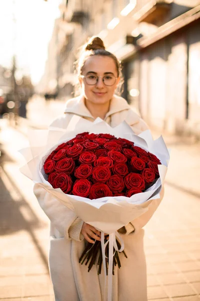 Νεαρό Κορίτσι Κρατώντας Πολυτελή Φωτεινό Μπουκέτο Από Κόκκινα Τριαντάφυλλα Στον — Φωτογραφία Αρχείου