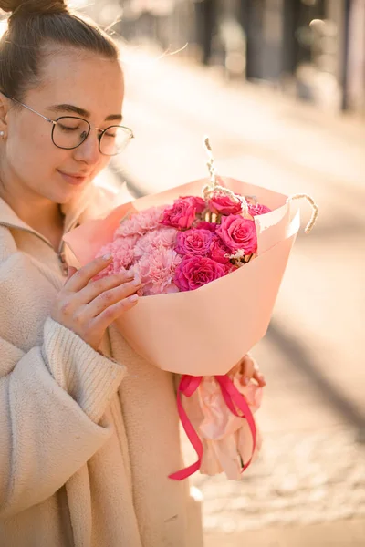 สาวสวยถ อดอกก หลาบส ชมพ สดและคาร เนช นในกระดาษห วยโลโก านดอกไม กองดอกไม — ภาพถ่ายสต็อก