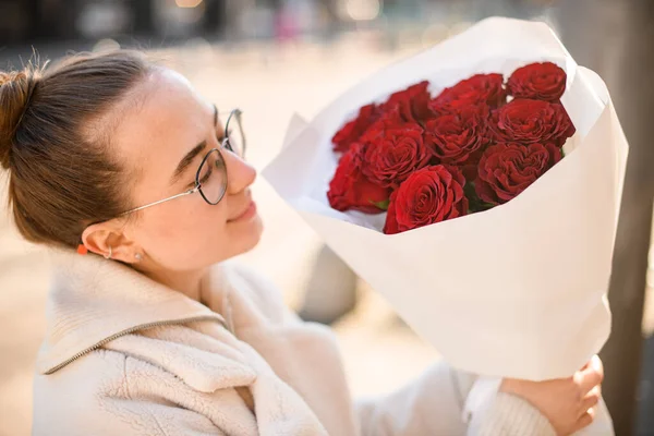 Vacker Flicka Som Håller Blombukett Ljusa Röda Rosor Vitt Omslagspapper — Stockfoto