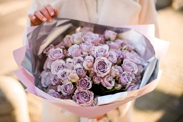 Güzel, narin bir buket ya da kızların elinde menekşe güllerinin yakın görüntüsü. Sevdiklerimiz için bir buket mor gül.