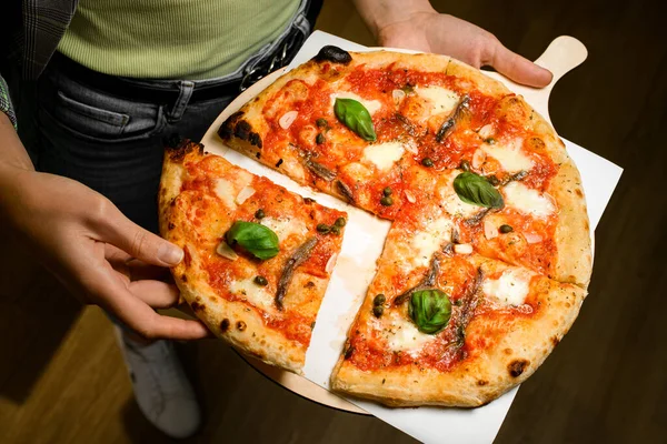 Restaraunt 노동자는 신선한 맛있는 이탈리아어 피자를 나무로 쟁반에 붙들고 조각을 — 스톡 사진
