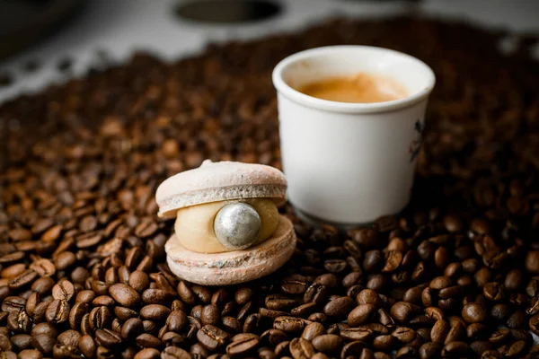 在新鲜烘焙的咖啡豆上 可以看到一杯白咖啡 加上咖啡和栗子的美味佳肴 早上的早餐甜蜜的礼物咖啡和糖果制品 — 图库照片