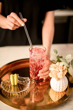 Çıplak manikürlü kız garson kız bardağa limonata ya da meyve suyuyla saman sokuyor. Kadın müşterileri kafe ya da restoranda sipariş veriyor.