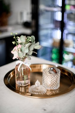 Klasik metal tepside inanılmaz manzara, şeffaf eski moda vazo, badem kurabiyesi ve küçük çiçek demeti. Kahve dükkanı ya da iç mekan. Müşteri siparişi veriliyor