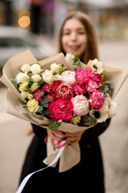 Seçici odak noktası protea, güller, şakayıklar, kadın çiçekçilerin ellerine sarılı el işi kağıtlar. - Evet. Kadın elinde egzotik çiçekli bir buket tutuyor. Çiçek.