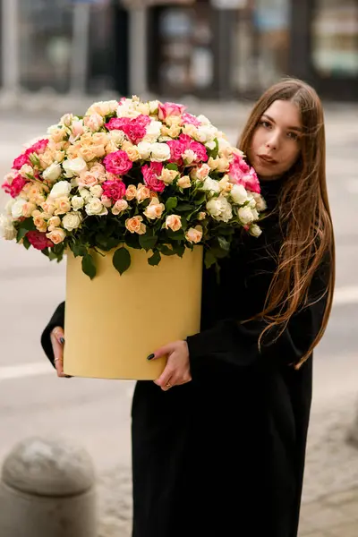 สาวสวยท ผมด ายาวย นอย บนถนนและถ อกล องกลมส เหล องขนาดใหญ ดอกก — ภาพถ่ายสต็อก