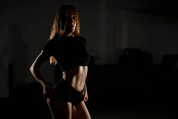 适合的模型显示腹肌和扁平的腹部与汗水在皮肤上运动后 漂亮的运动女孩 形状腹部 带有黑色背景复制空间的水平画室拍摄 — 图库照片