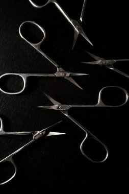 Profesyonel olarak aynı gümüş manikür makasları siyah arka planda izole edilmiş, tırnak etlerini kesmiş, manikür ve pedikür yapmış.