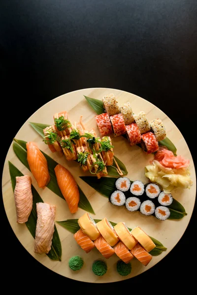 Různé Sushi Role Kulaté Dřevěné Desce Izolované Černém Pozadí Losos — Stock fotografie
